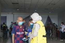 Tenaga kerja Indonesia (TKI) saat tiba di Bandara Internasional Kualanamu, Deli Serdang, Sumatera Utara, Kamis 9 April 2020. (Foto: VOA/Anugrah Andriansyah)