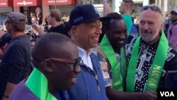 Artiss Russell Simmons (bertopi hitam) ikut meramaikan acara Muslim Day Parade di kota New York, Minggu (25/9). (foto: Ian Umar/VOA).