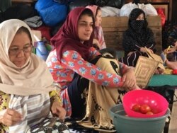 Para wanita pengungsi asal Afghanistan beristirahat di tenda darurat.