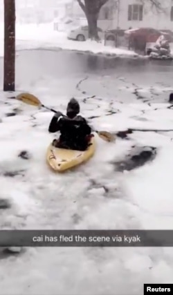 A person kayaks along a flooded street in Winthrop, Massachusetts, in this image taken from a Jan. 4, 2018, social media video. @odriscoll99/via Reuters