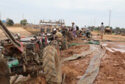 Farmers use two-wheel tractors to pump water from a twenty-kilometer irrigation system built by a Chinese company in Cambodia's western Pursat province, December 18, 2019. (Sun Narin/VOA Khmer)