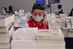 Seorang pengunjung pameran buku di Jakarta mengenakan masker untuk melindungi dari penularan virus corona, 8 Maret 2020. (Foto: AFP)