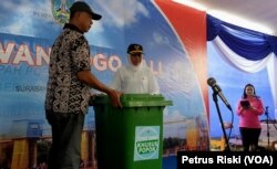 Gubernur Jawa Timur Khofifah Indar Parawansa menyerahkan kotak sampah khusus popok kepada Lurah Kebonsari, sebagai simbolis bantuan dropbox sampah popok untuk 99 titik jembatan (foto Petrus Riski-VOA)