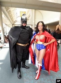 Pasangan suami istri Ken dan Michelle Camarillo, sebagai Batman dan Wonder Woman costumes, berpose pada hari kedua Comic-Con International 2015 di San Diego Convention Center, 10 Juli 2015, di San Diego.
