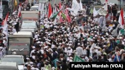 Massa dari dua kubu, pro dan anti Gubernur DKI Jakarta non aktif Basuki Tjahaja Purnama melakukan aksi unjuk rasa di depan Pengadilan Negeri Jakarta Utara, Selasa (27/12). (VOA/Fathiyah Wardah).