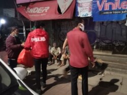 Tim PSI membagikan makanan siap saji kepada tunawisma di kawasan Tanah Abang dan Karet Jakarta pada 27 April 2020. (Foto: PSI)