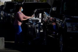 Para nakes menunggu di mobil untuk menjalani vaksinasi COVID-19 di San Diego, California (dok: AP/Gregory Bull)