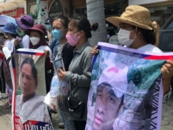 រូបឯកសារ៖ អ្នកតវ៉ានៅ​សាលា​ដំបូង​រាជធានី​ភ្នំពេញ កាល​ពី​ថ្ងៃ​ទី​១ ខែ​កក្កដា ឆ្នាំ​២០២១ កាន់​រូបថត​លោក តុន និមល អាយុ​៣៨ឆ្នាំ និង​អ្នកស្រី យ៉យ ស្រីមុំ អាយុ​៥០ នៅពេល​តុលាការ​ក្រុង​ភ្នំពេញជំនុំជម្រះ​ អ្នកចូលរួម​តវ៉ា​ក្នុង​ព្រឹត្តការណ៍​២៣តុលា ឆ្នាំ២០២០ នៅ​មុខ​ស្ថានទូត​ចិន ប្រចាំ​កម្ពុជា។ (ហ៊ុល រស្មី/វីអូអេ)