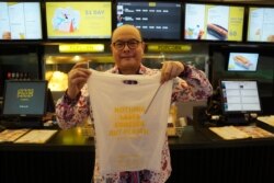 David Hilman memperlihatkan tas plastik dari singkong yang digunakan di Flix Cinema. (Foto: VOA/Henry Irvin)