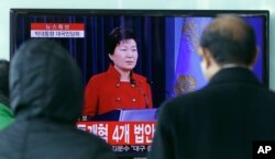 FILE - People watch a live broadcast of South Korean President Park Geun-hye's press conference, at the Seoul Railway Station in Seoul, South Korea, Jan. 13, 2016. Park called for resumption of nuclear talks, even if Pyongyang does not participate.