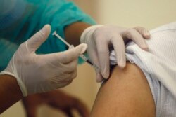 A Cambodian nurse gives a shot of the COVID-19 vaccine at Calmette hospital in Phnom Penh, Cambodia, Wednesday, Feb. 10, 2021. Cambodia began its inoculation campaign against the COVID-19 virus with vaccines donated from China, the country’s closest ally. (AP Photo/Heng Sinith)