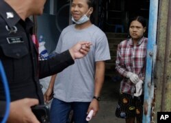 FILE - Burmese workers Tin Nyo Win, left, and Mi San smile upon being reunited in Samut Sakhon, Thailand, Nov. 9, 2015. They were separated while trying to escape the shrimp shed where they were held as slaves.