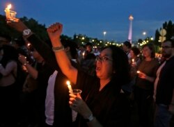 Aktivis memegang lilin dan meneriakkan slogan-slogan saat berjaga untuk seorang gadis remaja yang diperkosa dan dibunuh oleh 14 pria di Bengkulu, di luar istana presiden di Jakarta, 4 Mei 2016. (Foto: AP)