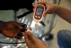 Seorang paramedis (kanan) memeriksa kadar gula darah pasien di klinik SS Diabetes Care di Jakarta, 22 April 2016. (Foto: REUTERS/Beawiharta)