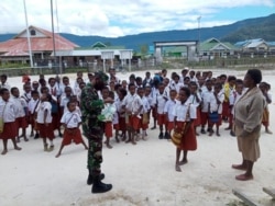 Babinsa Koramil 02/Tigi, Kodim 1703/Deiyai, membagikan masker secara gratis di SD YPPK ST.MIKHAEL, Kampung Mugouda, Distrik Tigi, Kabupaten Deiyai, 29 September 2021. (Courtesy: Pendam XVII/Cenderawasih-Papua)