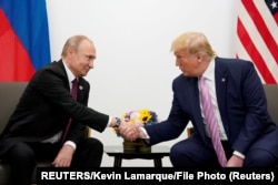 Arhiva - Predsednik Rusije Vladimir Putin rukuje se sa predsednikom SAD Donaldom Trampom, tokom bilateralnog sastanka na marginama samita idera G20, u Osaki, Japan, 28. juna 2019.