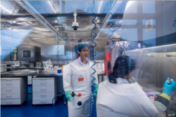 资料照:武汉病毒研究所的病毒学家石正丽(左)在该所的P4实验室内。