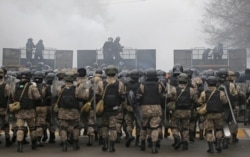 Kazakh law enforcement officers are seen on a barricade during a protest triggered by fuel price increase in Almaty, Kazakhstan, Jan. 5, 2022.