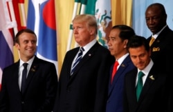 Presiden Perancis Emmanuel Macron bereaksi ketika Presiden AS Donald Trump memandang di samping Presiden Indonesia Joko Widodo dan Presiden Meksiko Enrique Pena Nieto pada KTT para pemimpin G20 di Hamburg, Jerman 7 Juli 2017. (Foto: REUTERS/Wolfgang Ratta
