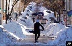 Mollie Lane digs her car out in the South Boston neighborhood of Boston, Jan. 5, 2018. Frigid temperatures, some that could feel as cold as minus 30 degrees, moved across the East Coast on Friday as the region attempted to clean up from a massive winter storm.