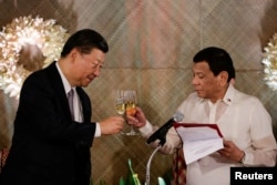 FILE - China's President Xi Jinping and Philippine President Rodrigo Duterte toast during a State Banquet at the Malacanang presidential palace in Manila, Philippines, Nov. 20, 2018.