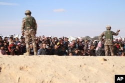 FILE - Syrian refugees wait to be approved to get into Jordan, in the Hadalat reception area, near the northeastern Jordanian border with Syria, and Iraq, near the town of Ruwaished, Jan. 14, 2016.