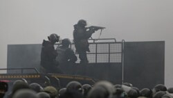 Kazakh law enforcement officers are seen on a barricade during a protest triggered by fuel price increase in Almaty, Kazakhstan Jan. 5, 2022.