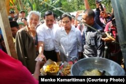 Direktur Pelaksana IMF Christine Lagarde, Ketua Panitia Nasional Penyelenggara Pertemuan IMF-Bank Dunia 2018 Luhut Binsar Panjaitan dan Menteri Keuangan Sri Mulyani menikmati jajanan khas Lombok ketika berkunjung ke Desa Guntur Macan, Lombok, Senin (8/10)