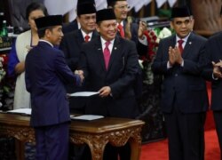 Presiden RI Joko Widodo disambut Ketua Majelis Permusyawaratan Rakyat Bambang Soesatyo seusai pengambilan sumpah saat pelantikan presiden periode kedua, di Gedung DPR, Jakarta, 20 Oktober 2019. (Foto: Adi Weda via REUTERS)
