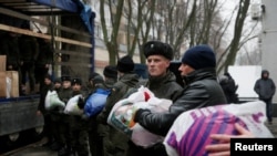 Members of the Ukrainian National Guard load humanitarian aid parcels for the government-held industrial town of Avdiivka to a truck in Kyiv, Ukraine, Feb. 3, 2017.