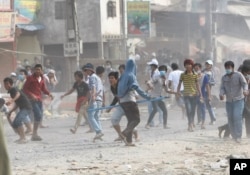 រូបឯកសារ៖ កម្មករ​រោងចក្រ​កាត់​ដេរ​ជា​ច្រើន​នាក់​បាន​នាំ​គ្នា​គប់​ដុំ​ថ្ម​ដាក់​កង​រាជអាវុធ​ហត្ថ​ដែល​ប្រដាប់​ដោយ​កាំភ្លើង នៅក្នុង​ការ​ធ្វើ​បាតុកម្ម​តវ៉ា​មួយ​នៅ​សង្កាត់​ស្ទឹងមានជ័យ រាជធានី​ភ្នំពេញ កាលពី​ថ្ងៃទី១ ខែ​ឧសភា ឆ្នាំ២០១៤។ (Reuters)