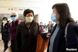 香港電台編導蔡玉玲 (照片中間) 在2021年1月首次出庭 (路透社資料照片）