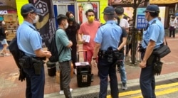 多名军装及便衣警员，截查摆街站反对当局收紧查册安排的工会成员 (美国之音/汤惠芸)