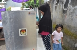 Seorang pemilih sedang melaksanakan hak pilih saat pilkada Tangerang, Banten 27 Juni 2018. (Foto: AFP)