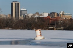 A buoy is encased in ice and snow along the James River near downtown Richmond, Va., Jan. 5, 2018. A winter storm swept through the area Thursday dumping several inches of snow. Bitter cold is expected through the weekend.