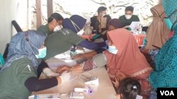 Beberapa warga lansia diperiksa oleh dokter dan perawat di sebuah Posko kesehatan (foto Petrus Riski-VOA).