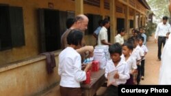 Im Chaem and a Christian missionary group handed out donated school supplies to students in Anlong Veng district, Oddar Meanchey province, Cambodia, November 2017. (Courtesy photo of pastor Touch Chanthou)