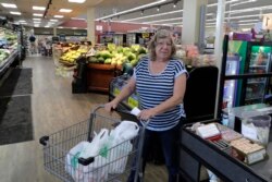 Laurie Mahlenbrei mendorong kereta berisi belanjaan setelah berbelanja di sebuah toko di Tenino, Washington, 4 Juni 2020. Laurie membayar belanjaan dengan uang kayu senilai $25. (Foto: AP)