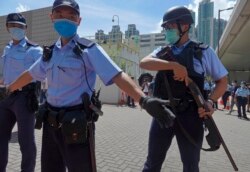 当香港首位被控涉嫌违反国安法的唐英杰坐着轮椅被押解至法院时港警戒备。（2020年7月6日）