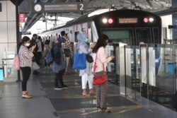 Para calon penumpang menunggu kedatangan KRL dengan menggunakan masker, di tengah pandemi COVID-19 di stasiun KRL di Jakarta, 8 Juni 2020.