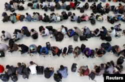 FILE - Cambodian fishermen rescued from Thai fishing boats have breakfast at a building in the Chroy Changva district of Phnom Penh, June 18, 2015.