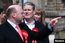 资料照： 英国议会下院跨党派商业及贸易委员会主席、曾任工党内阁大臣的利亚姆·伯恩（ 左 Liam Byrne）与英国现任首相斯塔默（中 Keir Starmer）在一个竞选集会上。（2021年5月21日）