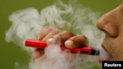 Seorang pria sedang mengisap rokok elektrik, 19 September 2019.
