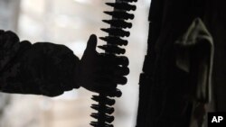 Seorang prajurit Ukraina menyentuh amunisi yang tergantung di posisi garis depan di kawasan Luhansk, Ukraina timur, Jumat, 28 Januari 2022, sebagai ilustrasi. Korea Utara diduga memasok amunisi dan alutsista ke Rusia. (Foto: AP)