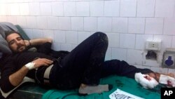 In this photo released by the Syrian official news agency SANA, A Syrian man receives treatment after U.S. troops opened fire on locals who tried to block a U.S. convoy driving near the village Khirbet Ammu, east of Qamishli city, Syria, Feb. 12, 2020.