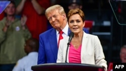 资料照片：2024年10月13日，在亚利桑那州普雷斯科特谷的芬德利丰田赛场举行的竞选集会上，时为美国共和党参议员候选人的卡丽·莱克(右)与时为共和党总统候选人和美国前总统的唐纳德·特朗普同台发言。