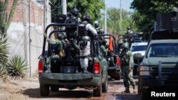 FILE - Federal forces guard the perimeter of a scene following a shootout where several suspected gang members were killed while one local cartel leader was arrested, on the outskirts of Culiacan, Sinaloa state, Mexico Oct. 22, 2024.