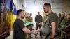 Presiden Ukraina Volodymyr Zelenskyy bersalaman dengan salah satu anggota pasukan Ukraina dalam kunjungannya ke garis depan pertempuran di Kota Pokrovsk, wilayah Donetsk, Ukraina, pada 26 Juni 2024. (Foto: Ukrainian Presidential Press Service/Handout via Reuters)