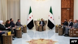 Pemimpin sementara Suriah Ahmed al-Sharaa (tengah) bertemu dengan anggota komite untuk menyusun deklarasi konstitusional bagi transisi negara tersebut setelah penggulingan penguasa lama Bashar al-Assad, di Damaskus, 2 Maret 2025. (Kepresidenan Suriah/AFP)