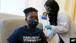 Julian Boyce (14), menerima vaksinasi Pfizer COVID-19 pertamanya di NYC Health + Hospitals/Harlem, New York, Kamis, 13 Mei 2021. (AP Photo/Richard Drew)